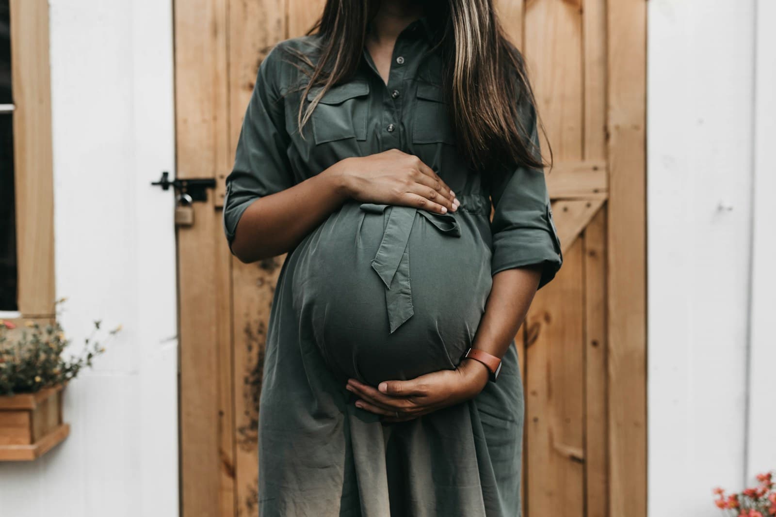An expecting parent pausing thoughtfully at home